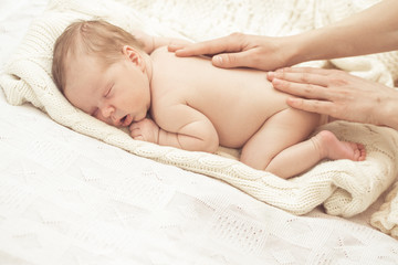 Mother massaging infant boy