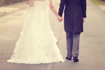 Fototapeta na wymiar Bride and groom walking on road