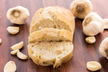 fresh baked loaf of bread with whole cloves of roasted garlic