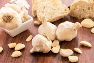 fresh baked loaf of bread with whole cloves of roasted garlic