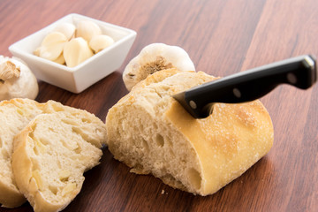 fresh baked loaf of bread with whole cloves of roasted garlic