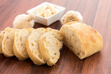 fresh baked loaf of bread with whole cloves of roasted garlic
