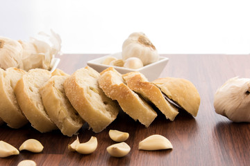 fresh baked loaf of bread with whole cloves of roasted garlic