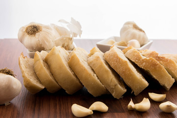 fresh baked loaf of bread with whole cloves of roasted garlic