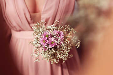 Hands of bridesmaid holding a beautiful gypsophila bouquet