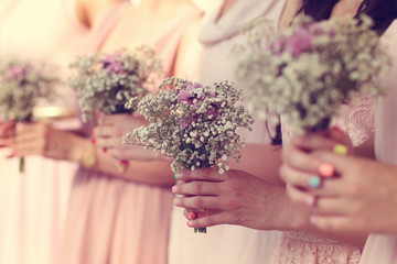 Hands of bridesmaid holding a beautiful gypsophila bouquet
