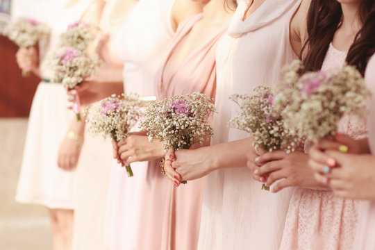 Hands of bridesmaid holding a beautiful gypsophila bouquet