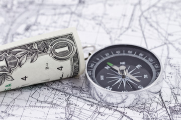 one-dollar bill and a compass lying on a map