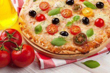 Italian pizza with cheese, tomatoes and basil