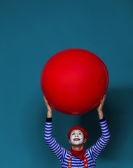 Mime with big red ball in hands