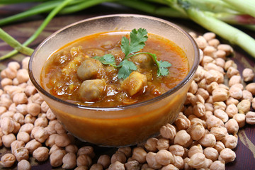 indian spicy chana masala with raw chickpeas and green onion