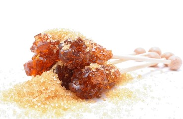 Brown sugar crystal on wooden stick and brown granulated sugar