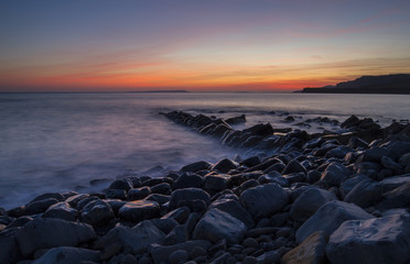 Obraz premium Kimmeridge Bay with wet rocks and sunset