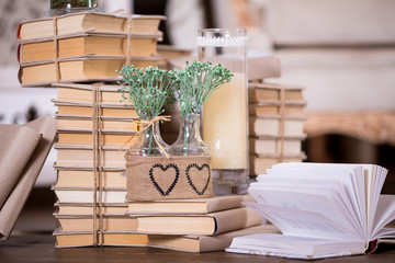 Old books heap and candle in interior decoration