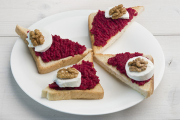 Sandwiches with red beet spread, goat cheese and walnut