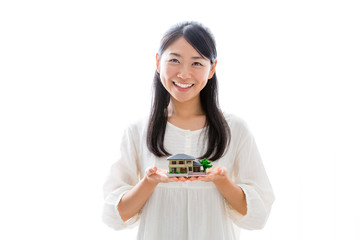 young asian woman with miniature house