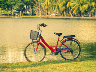 Fototapeta premium bicycle on green grass with lagoon background