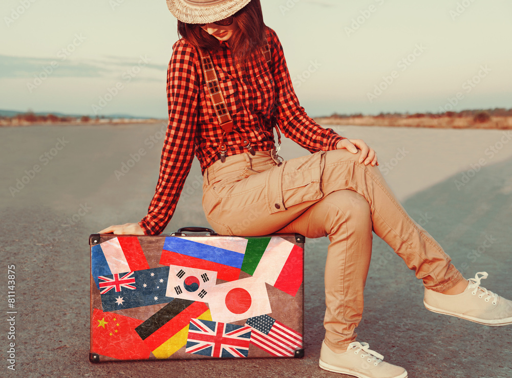 Wall mural Traveler sitting on a suitcase