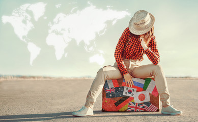Traveler woman sits on suitcase