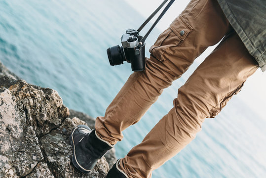 Traveler with camera standing on coast