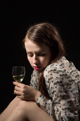 beautiful young brunette woman holding a glass of white wine