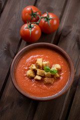 Ceramic bowl with gazpacho over dark rustic wooden background