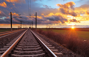 Orange Sonnenuntergang in niedrigen Wolken über der Eisenbahn