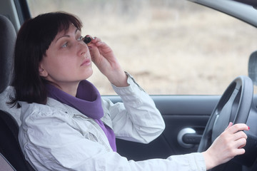 Woman wearing eyeliner in the car