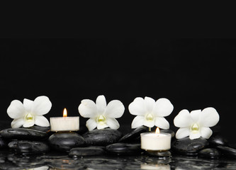 Fototapeta na wymiar White orchid with candle and therapy stones 