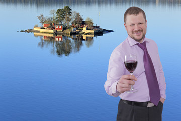 Businessman holding glass of wine with sea island in background