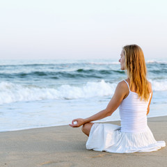 Woman meditating at the sea