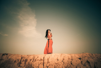 young woman in red dress on hill horizon