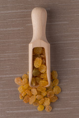 Wooden scoop with golden raisins