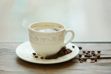 Cup of coffee on table on light background
