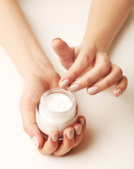 Female hands holding jar of cream isolated on white