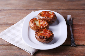 Baked potatoes on pate on wooden table