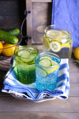 Fresh water with lemon and cucumber in glassware with napkin