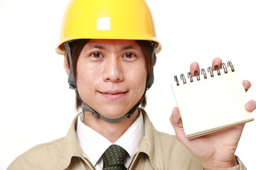 手帳を見せる作業員