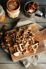 Dried mushrooms on cutting board on wooden background