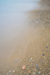 Waves crash onto a rocky, rugged coastline on an overcast mornin