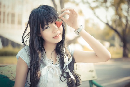 A cute Asian Thai girl with vintage clothings is picking a straw