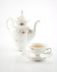 Old-style retro jug with tea on white background