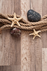 rope, starfish, sea stones on the old wooden background