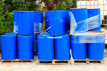 Old blue barrels on wooden pallets