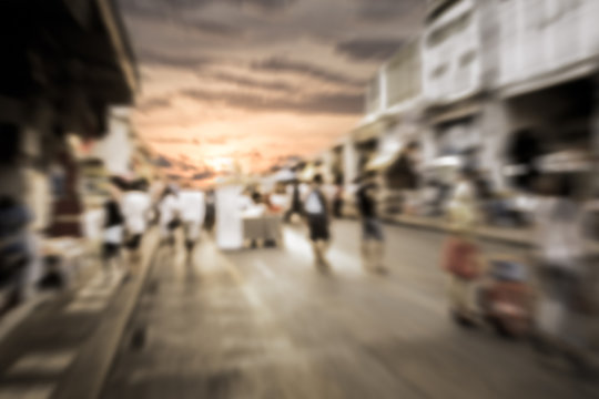 Blurred people walking on the street during sunset