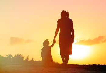 mother and little daughter walking at sunset - 81166292