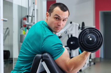 Obraz na płótnie Canvas Exercises for the biceps with dumbbells