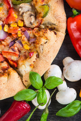 Fresh homemade vegeterian pizza with ingredients, overhead