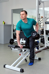 Fototapeta na wymiar Image of fitness guy in gym exercising with dumbbells
