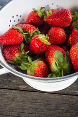 Sweet ripe strawberries in rustic colander